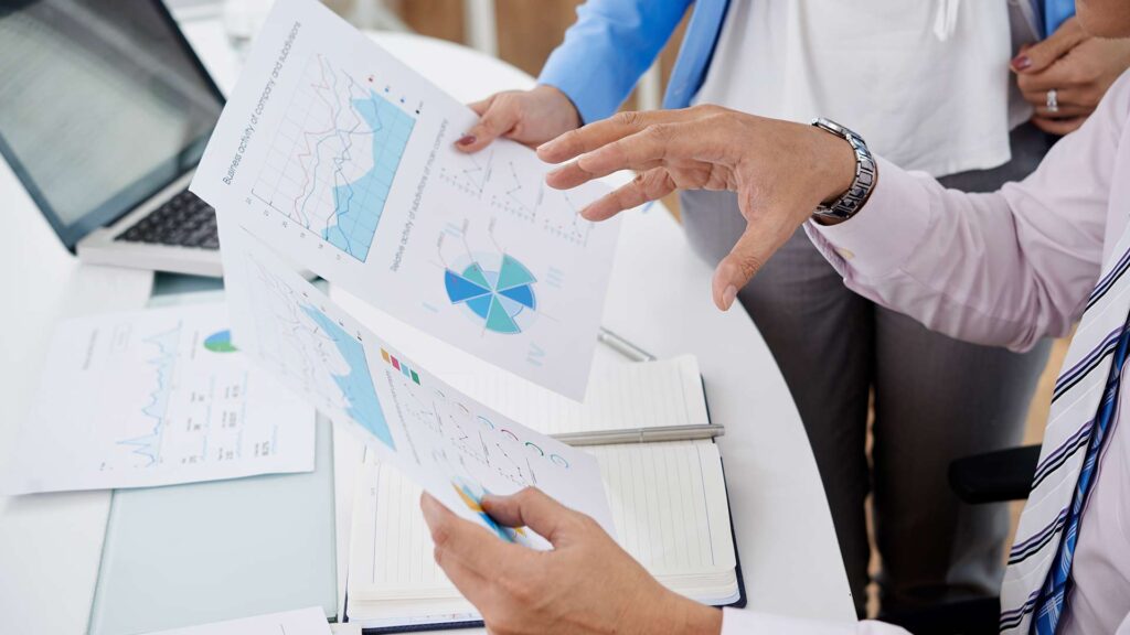 Team reviewing business analytics and safety metrics while implementing a health and safety management system during rapid organizational growth.